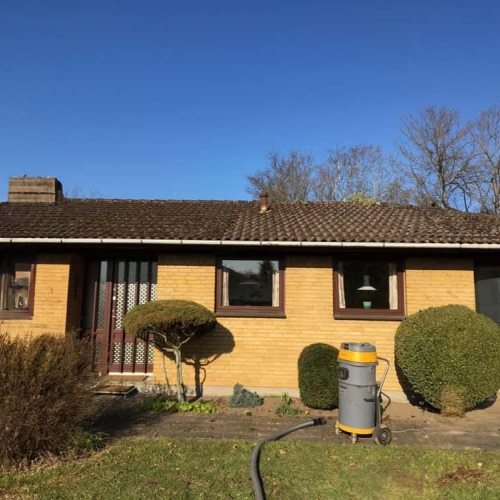 Algebehandling af tag på gult hus